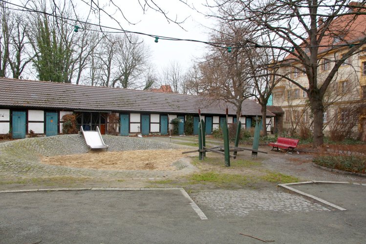 Ein Spielplatz mit Rutsche, Sandkasten und Sitzbank