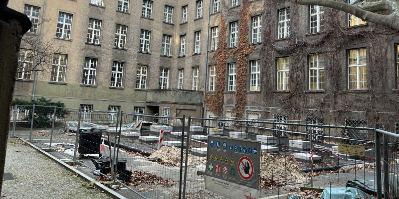 Innenhof mit eingezäunter Baustelle, umgeben von einem Gebäude