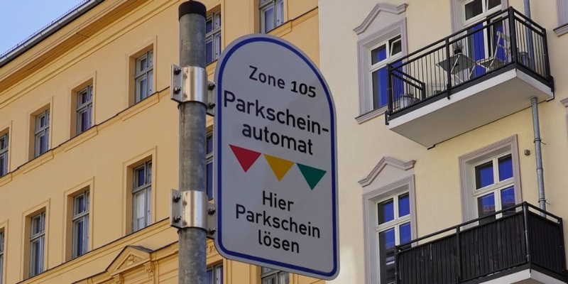 Schild zu einem Parkscheinautomat, im Hintergrund Wohnhäuser