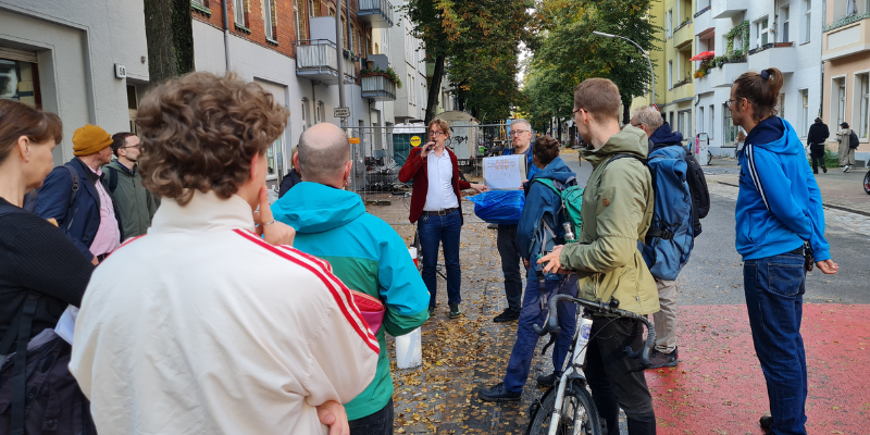 Menschengruppe versammelt sich auf der Straße und hört einer Präsentation zu