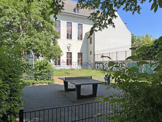 Ein leerer Spielplatz mit einer Tischtennisplatte im Sommer
