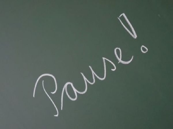 Auf einer Schultafel ist das Wort "Pause" geschrieben