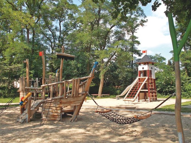 Spielgerät in Form eines Schiffes, Bäume im Hintergrund