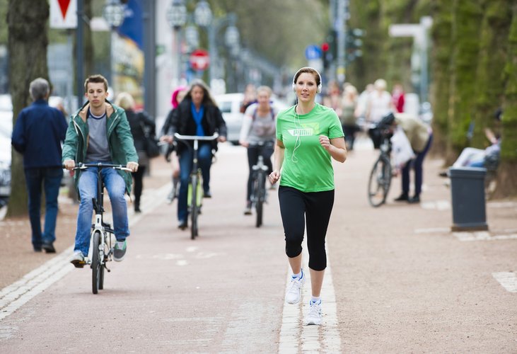 Joggerin und Radfahrer nebeneinander auf einem öffentlichen Weg