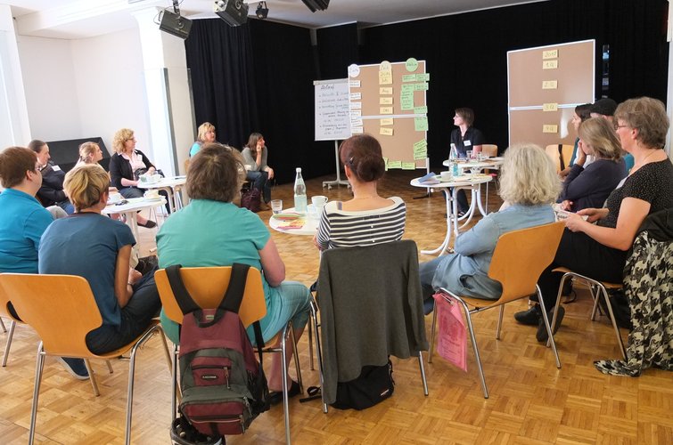 Menschen sitzen im Stuhlkreis